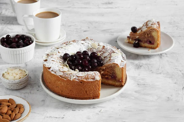 Bir fincan kahveyle servis edilen dondurulmuş çilekli frangipan turtası.