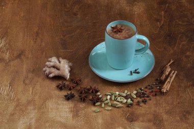 Geleneksel Hint içkisi. Baharatlı Masala çayı. Tarçın, kakule, anason, ahşap arka planda biber. Uzayı kopyala Yan görünüm