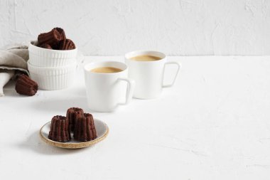 Canelle çikolatası beyaz masa üzerinde kahve fincanları olan geleneksel bir Fransız pastasıdır.