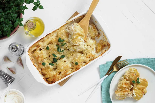 Güveç. Fransız mutfağı. Pişirmek için seramik tavada ev yapımı patates graten. Taze kekik yaprakları, zeytinyağı, sarımsak ve porsiyon tabağı. Üst görünüm kopyalama alanı
