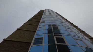 Camdan ve tuğladan yapılmış yüksek katlı bir binanın cephesi