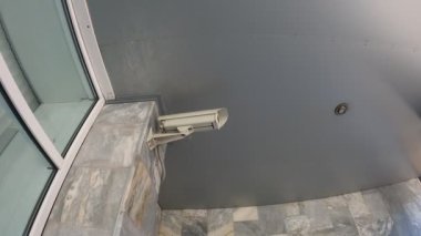 Binanın duvarındaki güvenlik kamerası şehrin sokaklarını koruyor.