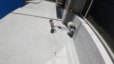 Binanın duvarındaki güvenlik kamerası şehrin sokaklarını koruyor.