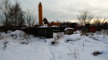 Abandoned Russian industrial area. Old factory, bare concrete in winter, non-working mechanisms, abandoned factory