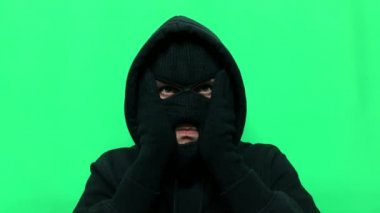 Kızgın genç adam bir hırsız oldu ve ilk mağaza soygunu için malzemelerini ve giysilerini yeşil bir arka planda hazırladı.