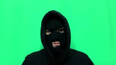 Kızgın genç adam bir hırsız oldu ve ilk mağaza soygunu için malzemelerini ve giysilerini yeşil bir arka planda hazırladı.