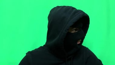 Kızgın genç adam bir hırsız oldu ve ilk mağaza soygunu için malzemelerini ve giysilerini yeşil bir arka planda hazırladı.