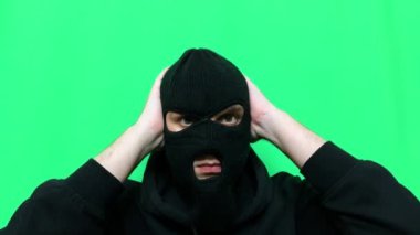 Kızgın genç adam bir hırsız oldu ve ilk mağaza soygunu için malzemelerini ve giysilerini yeşil bir arka planda hazırladı.