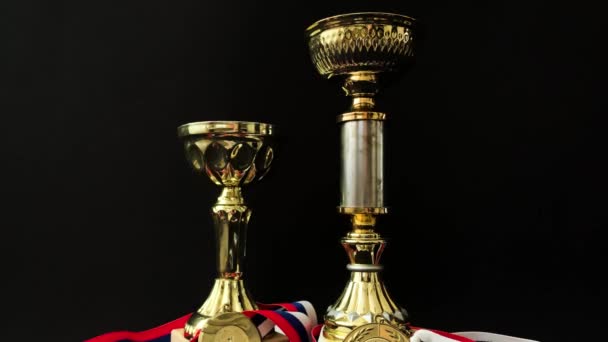 黒の背景に金 銅メダルとカップ 人々の前でのパフォーマンスと高レベルのスポーツの成果のための重要な賞の多数 — ストック動画
