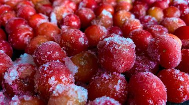 Kış mevsiminde soğuk kiraz. Birçok olgun kırmızı kiraz buz içinde masaya saçıldı.