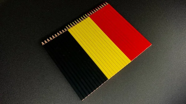 从铅笔中摘录作画用 折叠在比利时国旗上的铅笔 — 图库照片