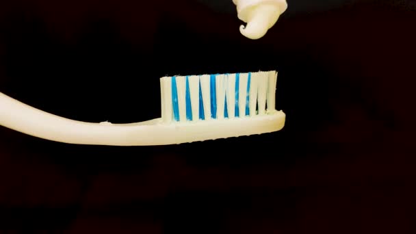 Bělení Zubní Pasta Šíří Přes Zubní Lístek Černém Pozadí — Stock video