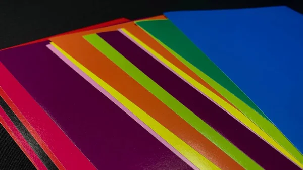 Többszínű Papír Kartonlapok Egy Fekete Asztalra Vannak Szórva — Stock Fotó