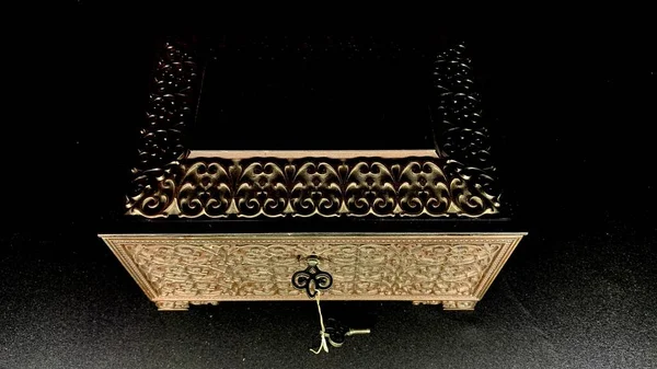 Antique metal chest with treasures and painted patterns of craftsmen, secret chest in a black cave