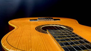 Metal telli ve siyah resimli, hafif ahşaptan yapılmış eski akustik gitar.