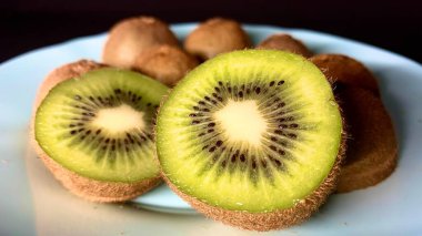 Bir egzotik kivi meyvesi masaya servis için tabakta yatar.