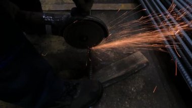 Atölyedeki ustabaşı makinedeki bir sonraki iş için siyah çelik demiri kesmek için öğütücü kullanıyor.