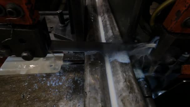 ワークショップのマスターは 金属のために見たバンドで動作し マシンはブレードを冷却するために石鹸水を使用して任意の角度で鋼のプロファイルをカットします — ストック動画