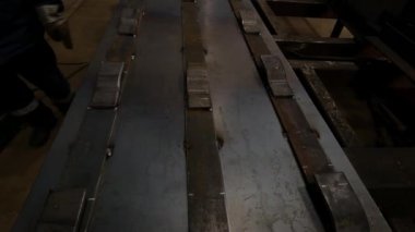 Metal atölyesi ustabaşı kaynak makinesi ve çelik bölmelerle çalışır.