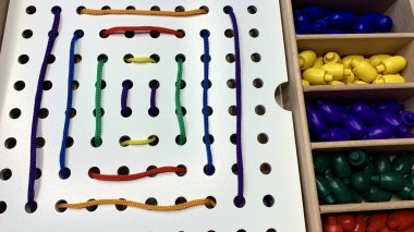 Renkli bağcıklar ve bağcıklar ile ince motor becerileri geliştirmek için çocuk oyunu