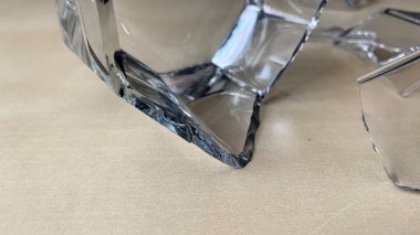 Viski bardağı birçok parçaya bölündü. Çatlaklar, bir bardaki ahşap masanın üzerindeki taş kırıkları.