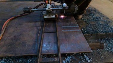 Metal işçiliği için raylı gaz kesme makinesi. Usta, metal üretimiyle ilgili bir fabrikada kesim makinesi ile çalışıyor.