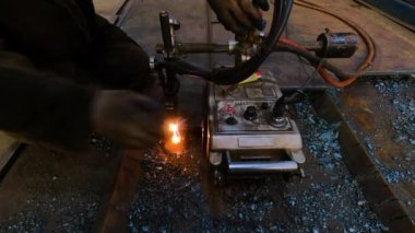 Metal işçiliği için raylı gaz kesme makinesi. Usta, metal üretimiyle ilgili bir fabrikada kesim makinesi ile çalışıyor.