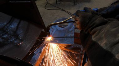 Fabrikadaki metal oymacılığı için gaz kesme makinesi. Usta, kurusıkı kesmek için bir makineyle çalışıyor.