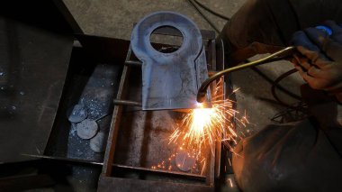 Fabrikadaki metal oymacılığı için gaz kesme makinesi. Usta, kurusıkı kesmek için bir makineyle çalışıyor.