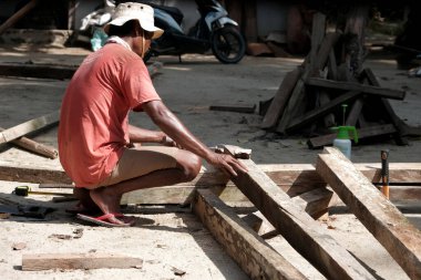 Lampung, Endonezya, 11 Şubat 2022. Endonezyalı bir marangoz sabah avluda bir ev için sütun inşa ediyor.