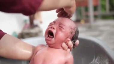 Küçük çocuk küvette annesi tarafından yıkanırken ağlar. Seçici odak