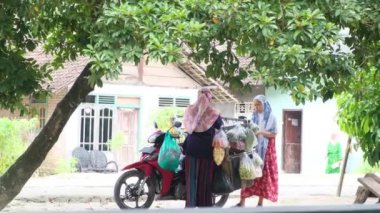 Lampung, Endonezya, Şubat 07 2022 - Endonezyalı kadınlar evden eve motosikletle dolaşarak köyde sebze satıyorlar
