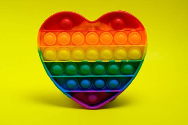 Pop It çocuk oyuncağı, anti-stres, oyuncak, moda oyuncağı, reklam amaçlı, sarı kağıt arka planda izole edilmiş, viral oyuncaklar, renkli, şişmiş,