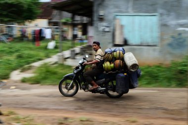 Lampung, Endonezya, 11 Mart 2022: gaz tüpleri taşıyan bir adamın bulanık hareketi