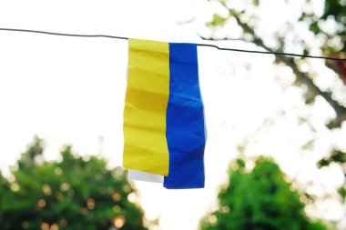 Ukrayna bayrağı konsepti. Kağıt bulanık bir arka planda Ukrayna ulusal renkleriyle boyanmış bir ipe asılı. Ukrayna bayrağı