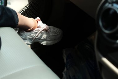 Özgürlük araba yolculuğu konsepti. Ayakları pembe spor ayakkabılar giymiş bir kadın arabada rahatlıyor. Arabadaki seksi kadın..