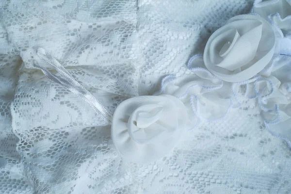 Beyaz brokar arka plan, kadın kıyafetleri üzerine ince ipekten detaylar. Motifleri olan güzel kumaş.