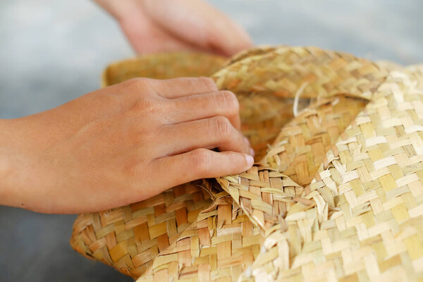 Женщина с корзиной из панданских листьев. Сельские женщины используют панданские листья для изготовления ремесел, чтобы создать ценность для местных материалов.