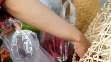 Plastik torbada sebze tutan bir kadın.