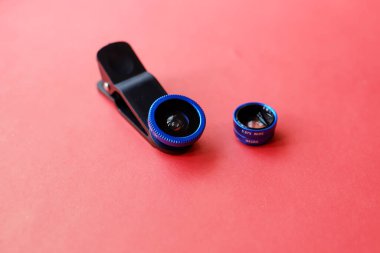 Kırmızı arkaplanda akıllı telefon için ek bir lens