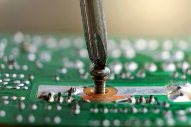 Tornavida ve cıvatalı elektronik devre kartı arkaplanını kapat