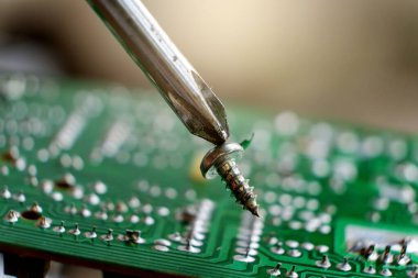 Tornavida ve cıvatalı elektronik devre kartı arkaplanını kapat
