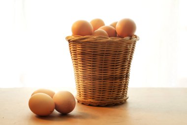 Tahta bir masada tavuk yumurtası sepeti.