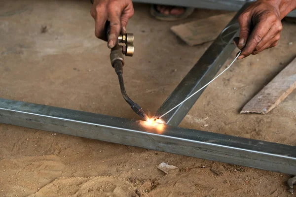 Erkek kaynakçı çelik çerçeve inşaatı yapıyor.