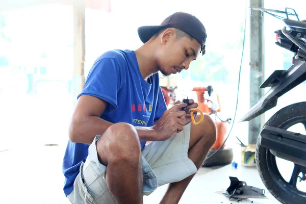 2022年4月26日 印度尼西亚兰榜 一名亚洲男子在摩托车修理店修理手中拿着钳子的摩托车 — 图库照片