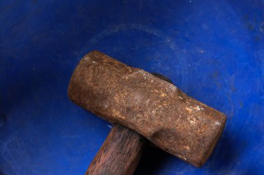 Mavi arka planda çok eski paslı metal çekiç.