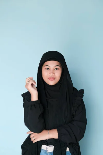 Muslim woman expression wearing hijab on a light blue background, studio shoot