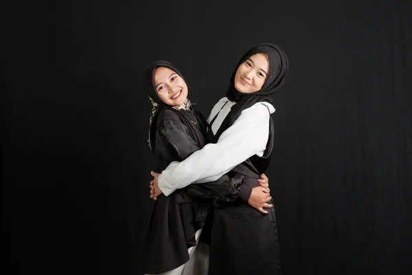 Δύο Ευτυχισμένες Νεαρές Ασιάτισσες Μουσουλμάνες Αλληλεπιδρούν Απομονωμένες Μαύρο Φόντο — Φωτογραφία Αρχείου