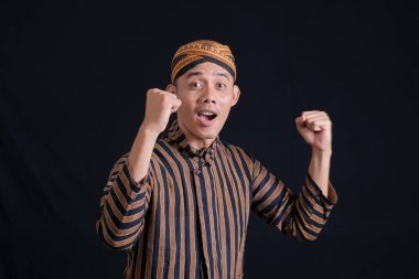Men wearing traditional Javanese batik clothes to show the richness of Javanese culture on a black background