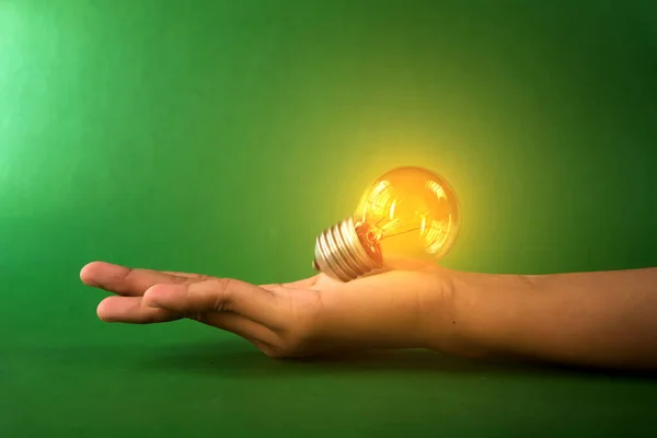 Glowing light bulb and innovation thinking creative concept in female hand, inspiration success with energy saving